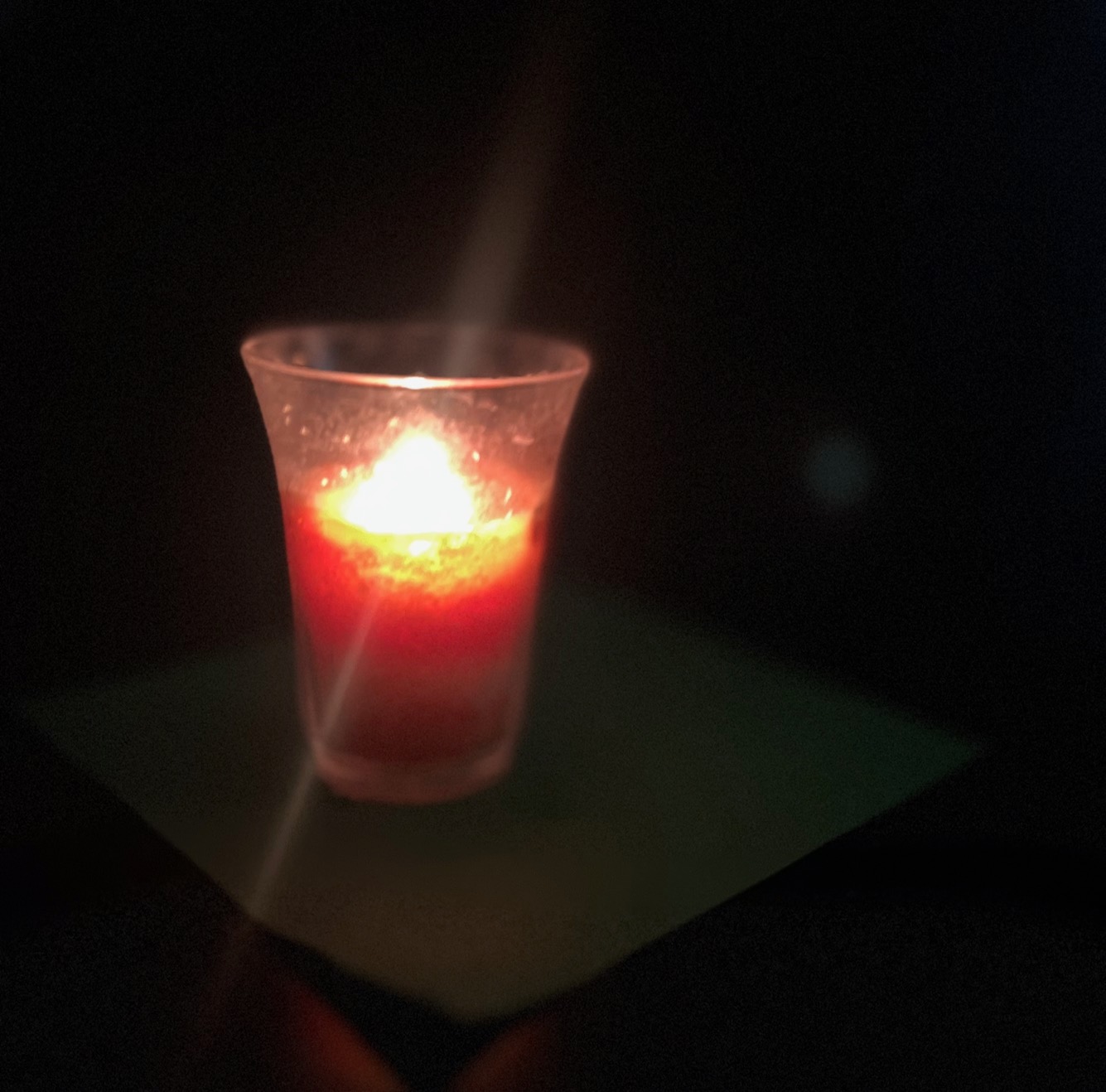 Picture of an orange candle on a near black background.